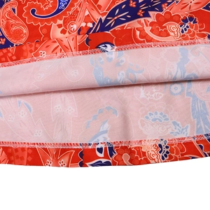 Close-up of paisley print fabric showing detailed white stitching on the hemline of a jumpsuit