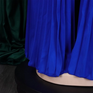 Detailed macro view of Klein blue pleated fabric showing fine texture and vertical accordion folds