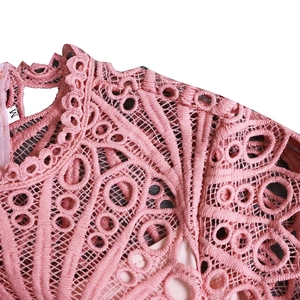 Detail of light pink lace dress showing intricate mesh pattern and back zipper closure