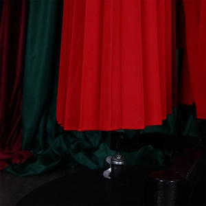 Close-up detail of a red pleated summer dress with fine accordion pleats and neat stitching