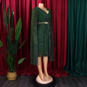 Detail view of emerald V-neck pleated dress with cape sleeves and gold belt accent