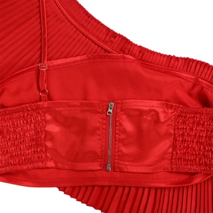 Detailed view of red pleated top featuring one-shoulder strap and metal zipper closure