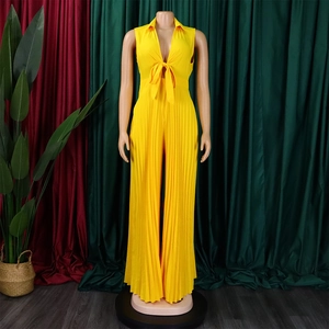 Detail of V-neck jumpsuit featuring yellow plissé fabric and elegant front bow knot