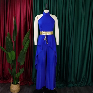 Detail of dark blue halter top with gold tassel belt and pleated wide leg trousers