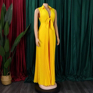 Detail of yellow V-neck jumpsuit featuring front knot and pleated wide-leg trousers design