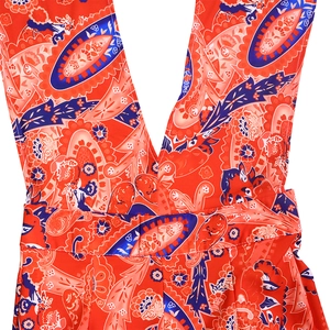 Close-up detail of the deep V-neckline and red paisley print fabric on the jumpsuit