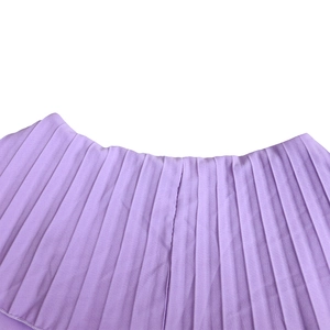 Détail de la jupe plissée lilas avec des plis accordéon fins et une taille élastique
