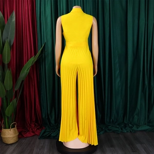 Macro detail of the bright yellow sleeveless jumpsuit showing pleated wide leg texture