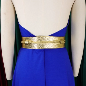 Close-up of golden snakeskin texture belt with braided cord details on a blue dress