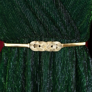 Detail of golden elastic spring belt with infinity symbol buckle on green dress