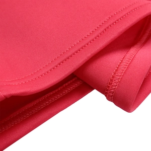 Close-up of professional stitching and elastic knit fabric texture on red dress
