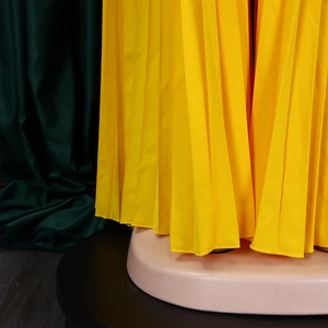 Detail of yellow pleated chiffon fabric showing fine vertical texture and flowing drape