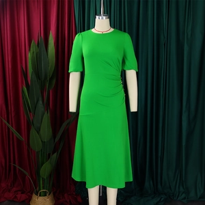 Detail view of bright green midi dress with ruched waist and decorative gold buttons