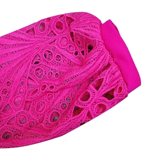 Detail of rose red lace crochet sleeve showing intricate hollow patterns and fine embroidery