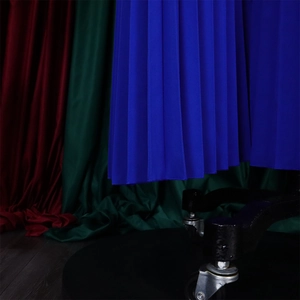 Detail view of royal blue pleated fabric texture and hemline of elegant women's jumpsuit