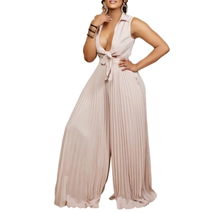 Detail of light beige pleated jumpsuit featuring deep V-neck and drawstring waist design