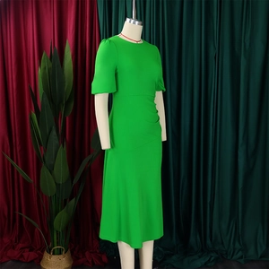 Detail of bright green slim-fit dress with puff sleeves and waist ruching details