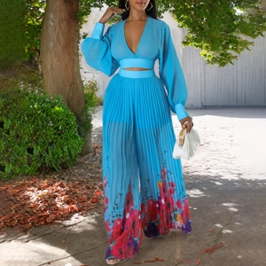 Detail of light blue pleated chiffon two-piece set featuring vibrant floral hem prints