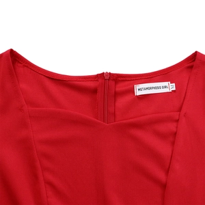 Détail de l'encolure de robe rouge avec étiquette de marque et fermeture éclair