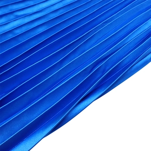 Detailed close-up of high-waist royal blue pleated skirt with silky satin fabric texture