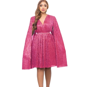 Detail of fuchsia pleated cape dress with metallic texture and gold waist belt