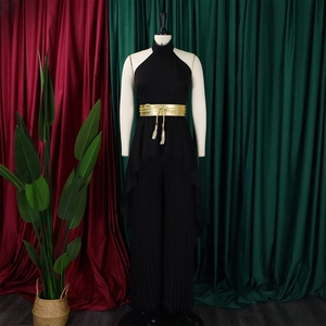 Detail view of black pleated wide-leg jumpsuit with elegant golden fringe tassel belt