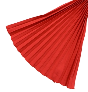 Détail du tissu plissé rouge vif montrant des plis accordéon fins et une texture soyeuse