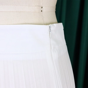 Detail of high waist white pleated pants featuring a seamless invisible side zipper