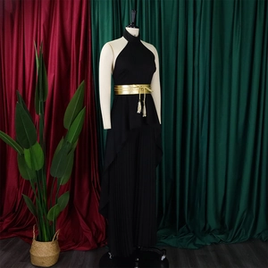 Detail of elegant black halter neck jumpsuit with a wide gold belt and pleated trousers