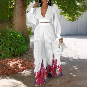 Detail of white two-piece set featuring pleated wide-leg pants with large floral print