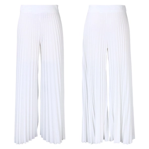 Detailed view of white pleated high-waisted wide-leg pants showing texture and draped fabric