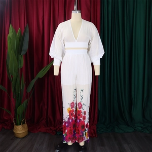 Detail of white V-neck crop top with puff sleeves and floral print wide leg trousers