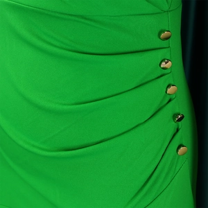 Detail of bright green ruched fabric with five decorative gold metallic buttons