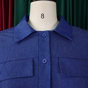 Détail de robe en jean bleu avec col pointu classique et poches de poitrine à boutons