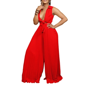 Detailed view of red deep V-neck jumpsuit featuring bow-tie waist and pleated wide-leg pants