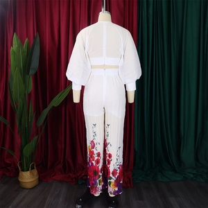 Detail view of the back zipper on a white long sleeve top and floral wide-leg pants