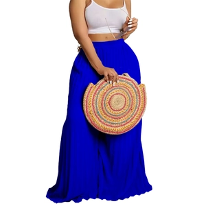 Detailed view of high-waisted pleated blue maxi skirt with white crop top vest set