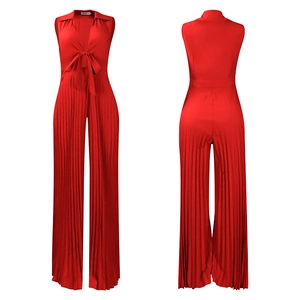 Detail of red V-neck pleated wide-leg jumpsuit with front lace-up and fine vertical textures