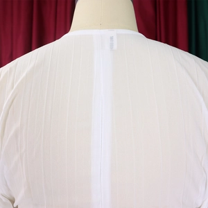 Detailed back view of white chiffon top featuring fine vertical pleated texture and branding tag