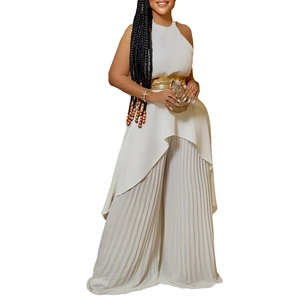 Detail of white halter neck top with irregular hem and pleated wide leg trousers