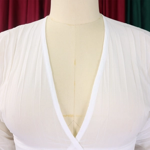 Close-up of white chiffon V-neck top with pleated texture on a mannequin model