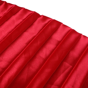 Detailed macro view of the pleated red satin fabric with elegant accordion folds