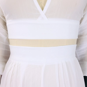 Detailed macro view of the pleated white chiffon waistline and layered sewing craftsmanship