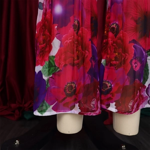 Detail of red and purple floral print on lightweight chiffon wide-leg trousers fabric