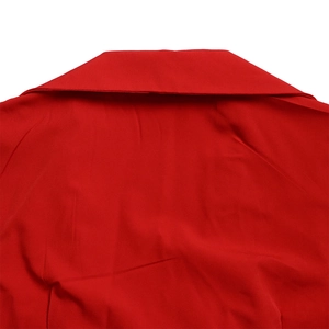 Detail view of the red jumpsuit's V-neck collar and pleated fabric texture