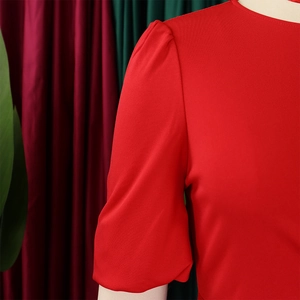 Close-up of red puff sleeves and pleated shoulder details on a crewneck dress