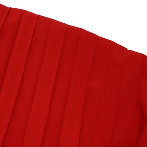 Detail of red pleated fabric with uniform vertical folds on a V-neck jumpsuit