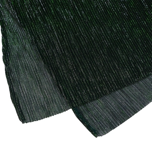 Macro detail of dark green metallic pleated fabric with shimmering light reflections