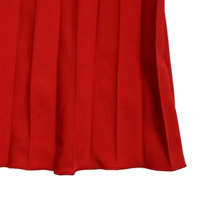 Detail of red pleated wide-leg jumpsuit showing precise knife pleats and hemline texture