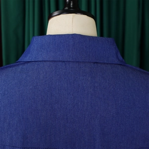 Vue détaillée des coutures du denim bleu foncé et de la texture du col d'une robe maxi